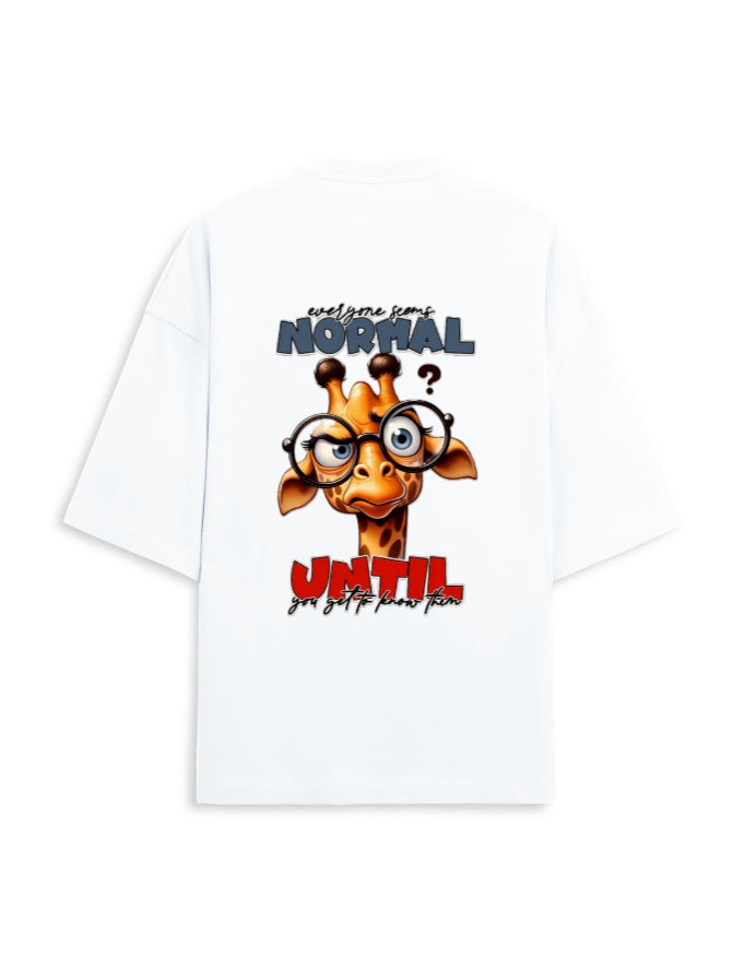 White oversized short-sleeve t-shirt showing the back graphic with a cartoon giraffe wearing glasses and the text 'welcome to NORMAL? UNTIL you get too smart again'.