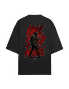 A black oversized t-shirt shown from the back, featuring a large graphic print with the words 'ONE STEP MORE' in distressed red lettering and a dark soldier silhouette.