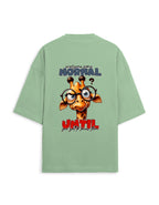 A sage green oversized t-shirt shown from the back, featuring a cartoon giraffe graphic with glasses and the text 'everyone is NORMAL until you get to know you'.