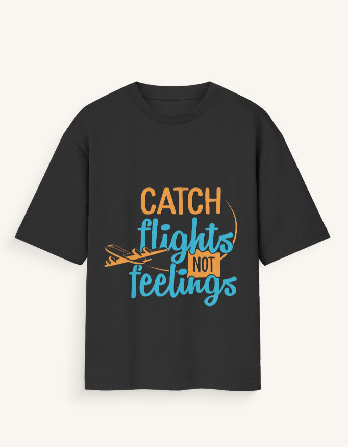 Front view of a dark navy blue unisex oversized streetwear t-shirt featuring a stylized airplane graphic and the text "CATCH FLIGHTS NOT FEELINGS" in orange and teal lettering across the center.