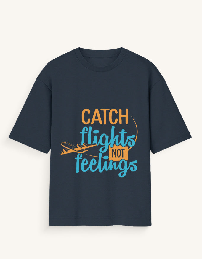Front view of a dark navy blue unisex oversized streetwear t-shirt featuring a stylized airplane graphic and the text "CATCH FLIGHTS NOT FEELINGS" in orange and teal lettering across the center.