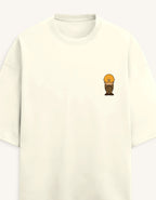 Front view of a premium white unisex terry oversized t-shirt featuring a small cartoon character graphic on the left chest pocket area.